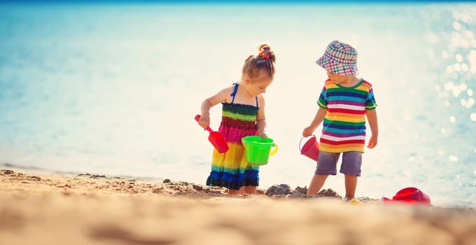Boy and girl playing on the beach on summer holidays