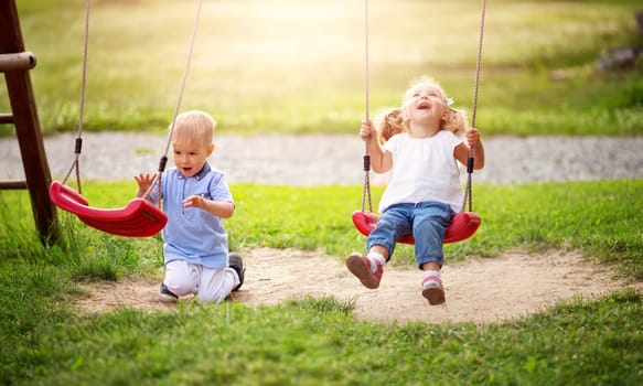 Boy and boy playing on the backyard on swings