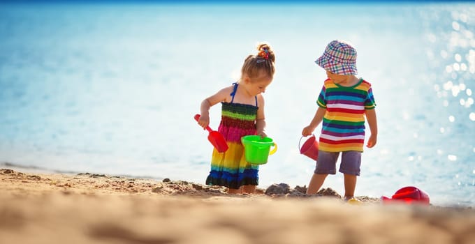 Boy and girl playing on the beach on summer holidays