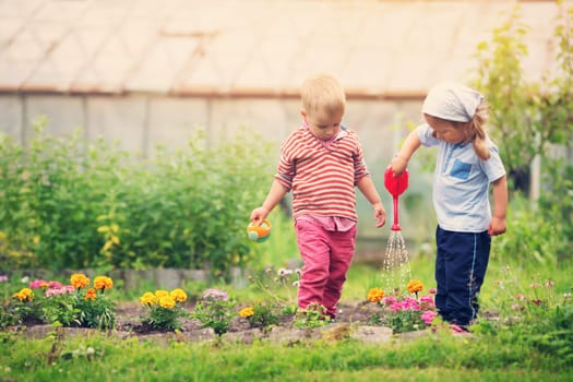 Boy and boy watering flowers in the garden