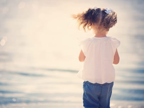 two years old girl standing at the sea