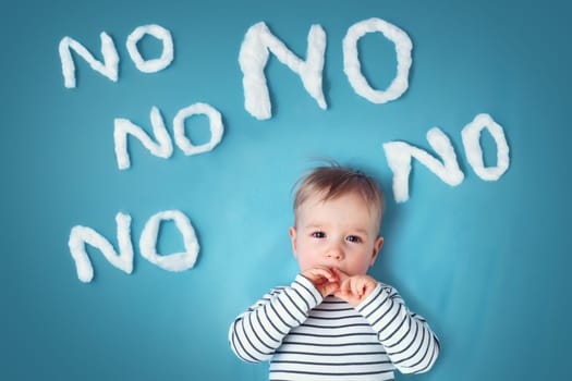 sad boy on blue blanket background. Unhappy child with no words around