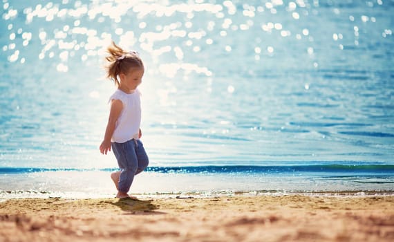 two years old girl running at the sea