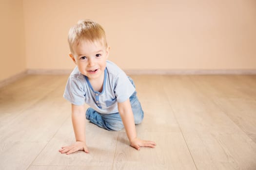 Portrait of a two years old child lying on the floor. Pretty little boy at home