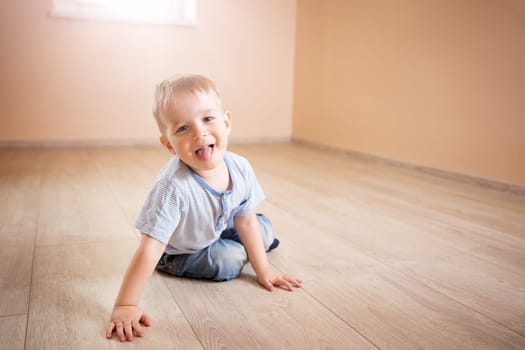 Portrait of a two years old child sitting on the floor. Pretty little boy at home