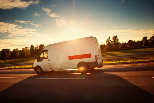 asphalt road with a small truck. van moving on sunny day