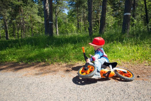children riding on a bicycles at gravel road in the park in summer