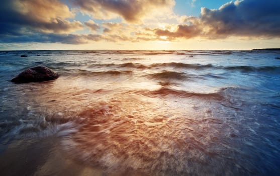 Seascape at sunset with rainy clous on the horizon
