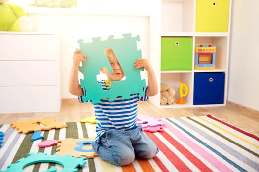 Little child playing with numbers. Boy sitting on the floor at home