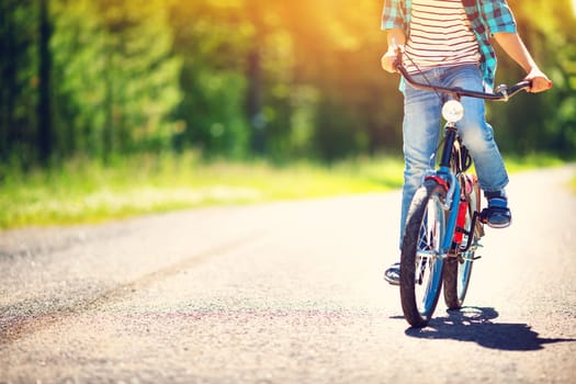 child on a bicycle at asphalt road in early morning