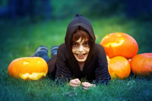 Child in scary costume holding pumpkin ln. Child in halloween outfit at night