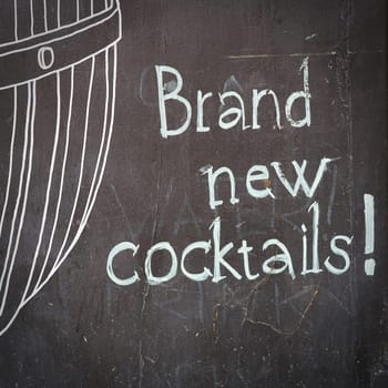 Slate board in front of a cocktail bar in Prague with the inscription "brand news Cocktails"""