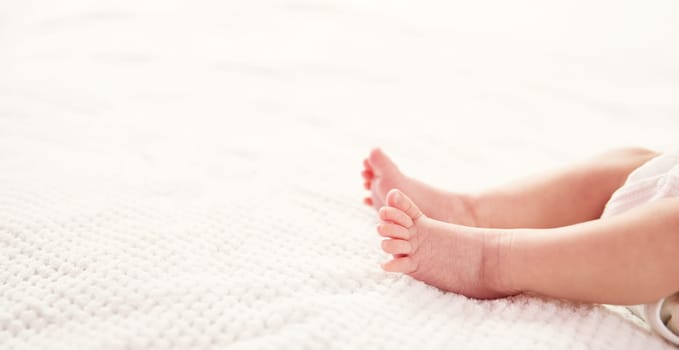 Cute newborn baby girl lying in the bed. Two weeks old infant child on white soft blanket
