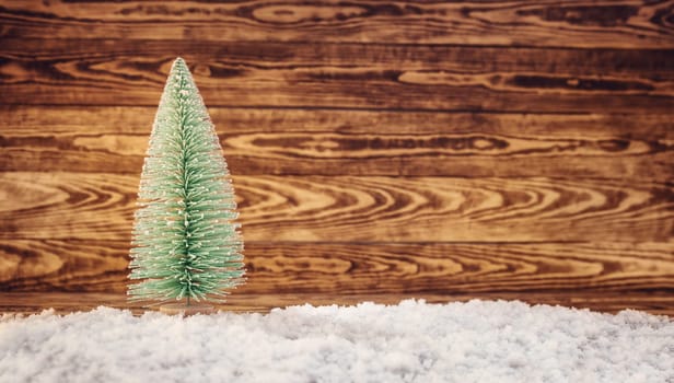 Old wooden planks with christmas trees. Brown background with snow and snowflakes