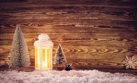 Old wooden planks with christmas decoration. Brown background with lantern and snow