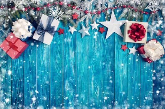 Christmas stars on wooden background with fir tree branches. Winter background