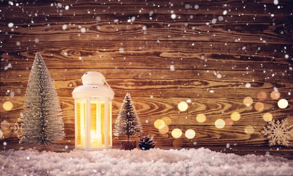 Old wooden planks with christmas decoration. Brown background with lantern and snow