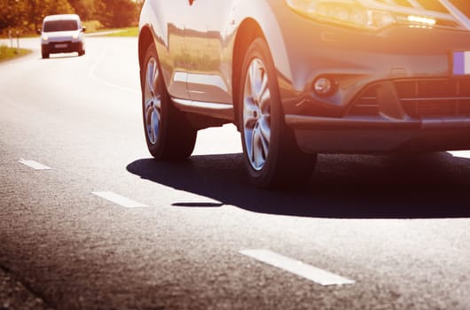 asphalt road view with a car in countryside at beautiful sunset
