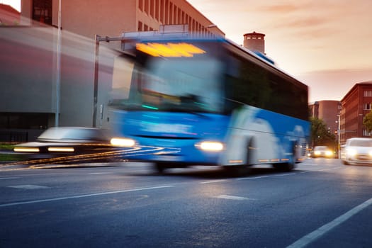 Bus moving on the road in city in early morning. View to the traffic with trafficlights and transport