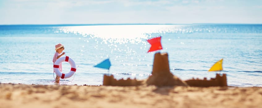 boy sitting smiling at the beach. Child on vacations at sea