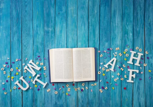 Open book on blue painted planks indoors