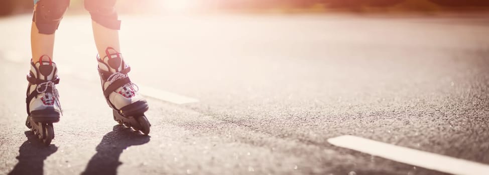 child on roller Skates at asphalt road in the evening