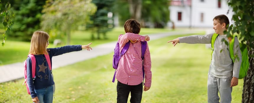 Children with rucksacks standing in the park near school. Pupils with books and backpacks outdoors