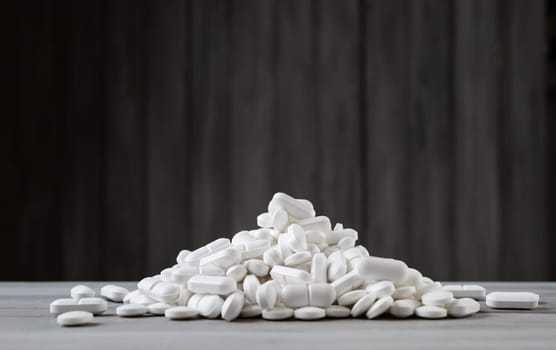 Pills spilled on gray background. A lot of white tablets