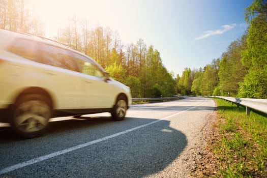 Car on asphalt road in beautiful spring day at countryside
