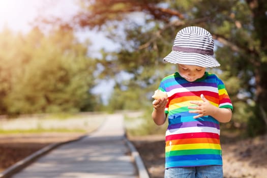 Happy child eating ice cream outdoors in summer. Portrait of a boy in sunglasses on sunny day