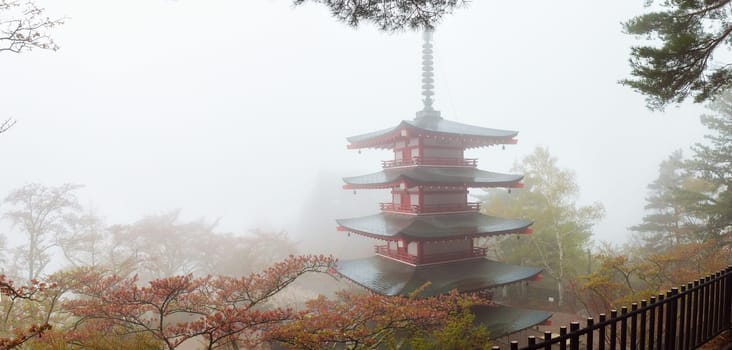 Chureito Pagoda near Fuji mountain at Fujiyoshida in Japan. Temple at Kawaguchiko in Arakura Sengen park on foggy day in spring with cherry blossoms