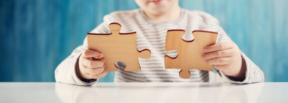 Little child holding puzzle pieces and trying to solve it. Problem solution concept