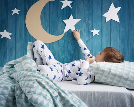 Five years old child sleeping in bed. Boy lying with closed eyes at night