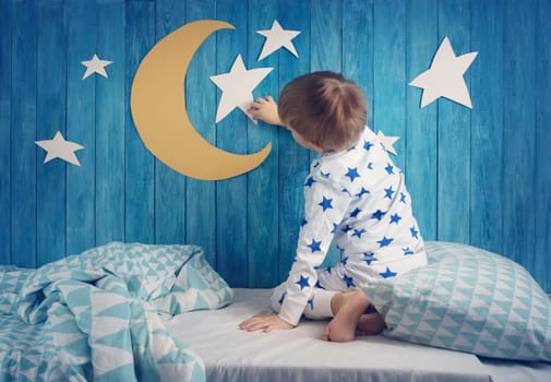 Five years old child sleeping in bed. Boy lying with closed eyes at night