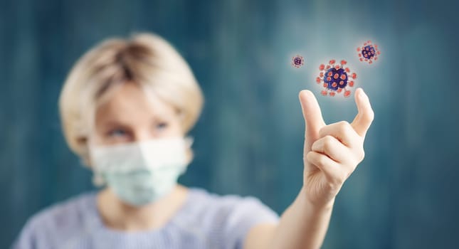 young woman in medical face protection mask indoors on blue background. Sick person