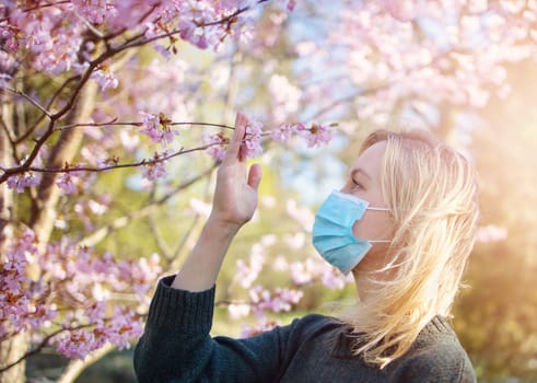 young woman in medical face protection mask outdoors in nature. Sick person