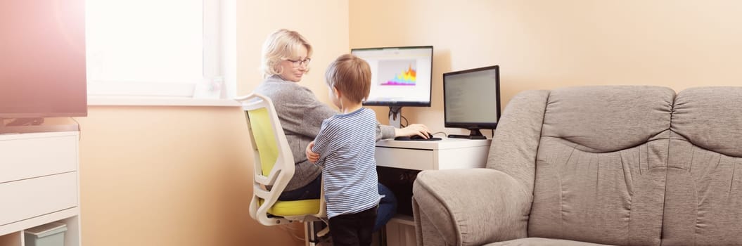 woman working at home with little child. Young businesswoman working indoors at pc