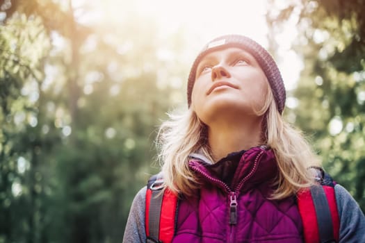 Young woman hiking and going camping in nature. Person with backpack walking in the forest