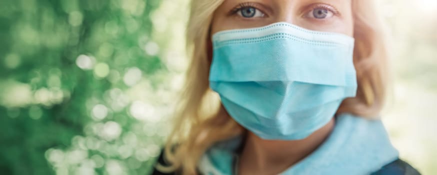 young woman in medical face protection mask outdoors in nature. Sick person
