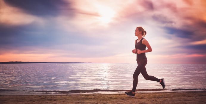 Young woman running on the beach near seaside at sunset. Active person outdoors at the dusk in summer