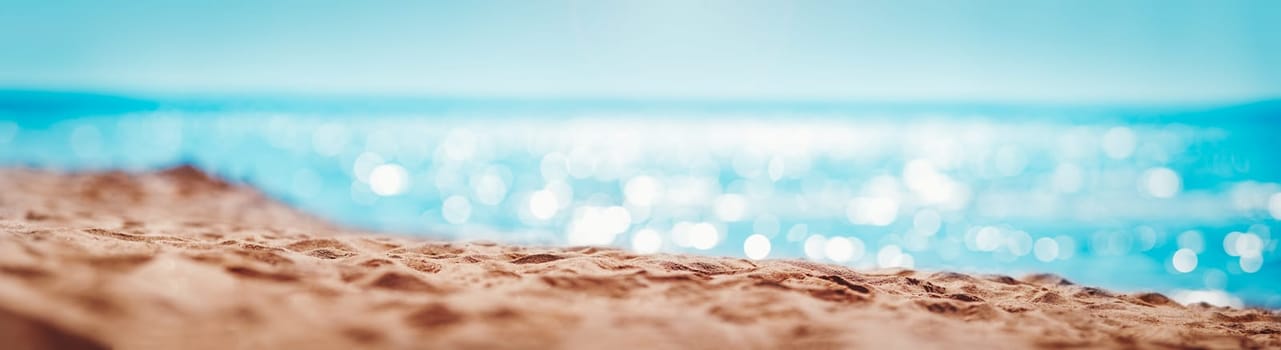 Blurred sea background with beautiful bokeh and sand on foreground