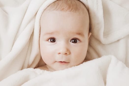 little boy sleeping on soft white blanket