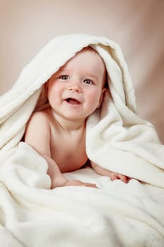 Cute eight month old baby wrapped in a towel. Baby hygiene. Adorable little boy