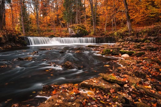 beautiful waterfall in autumn with blurred water in the river