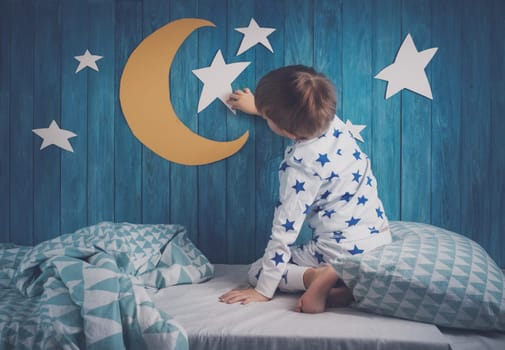 Five years old child sleeping in bed. Boy lying with closed eyes at night