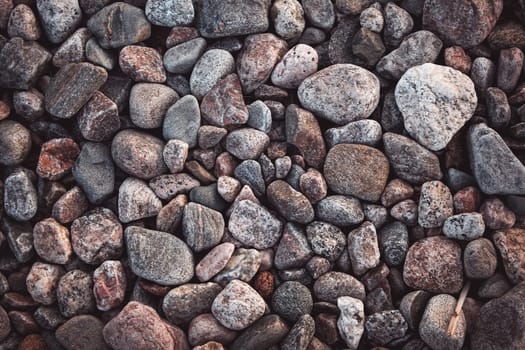texture with multicolored stones on rocky beach in summer
