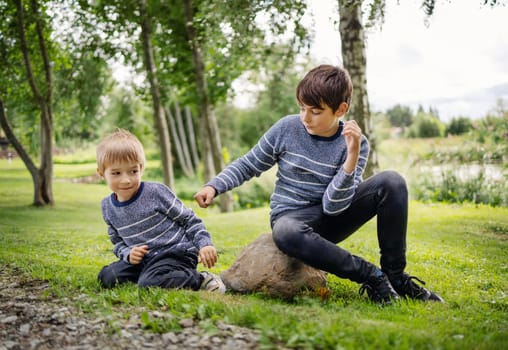 Two brothers fighting in park. Boys bullying