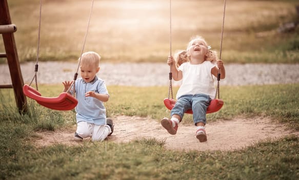Boy and boy playing on the backyard on swings