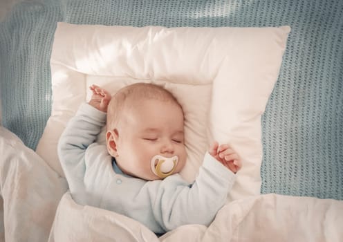 Four month old baby sleeping on blue blanket