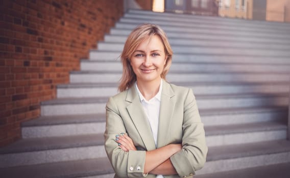 smiling young woman standing on the stairs. Person with in suit outdoors